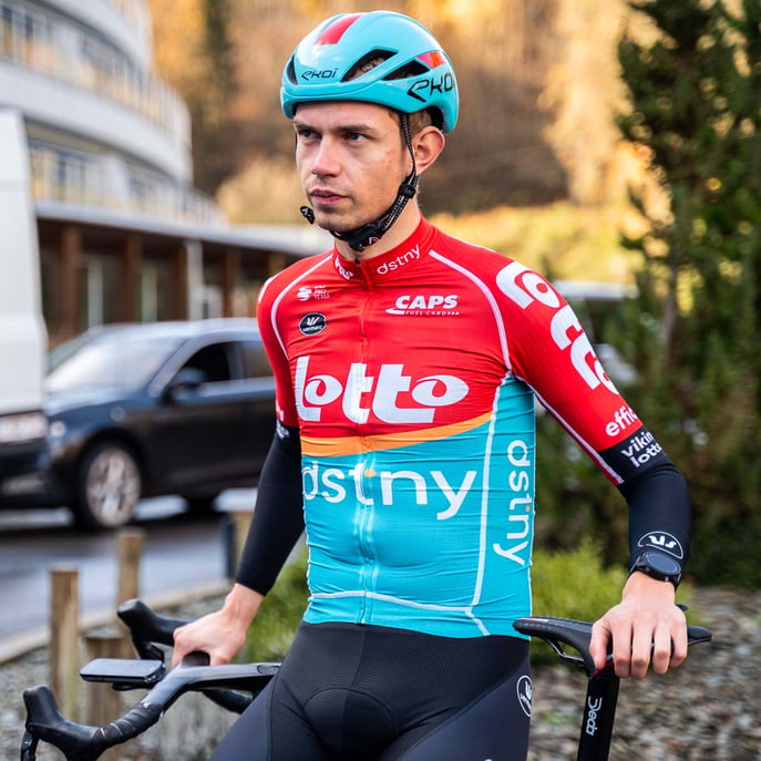 Andreas Kron i Lotto Dstny cykeltøj læner sig op af sin løbscykel