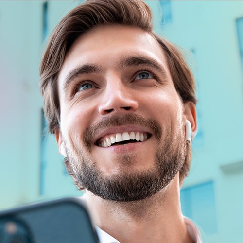 squared_smiling_man_with_phone_outdoors